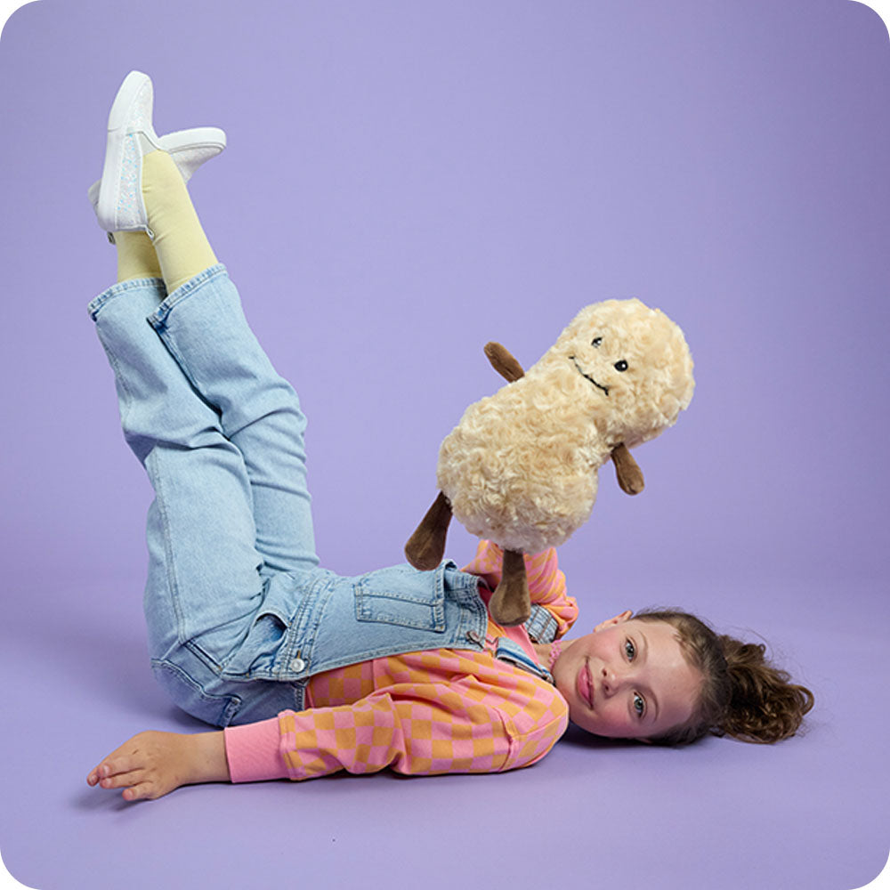 Image 102: girl holding up a peanut stuffed animal warmies